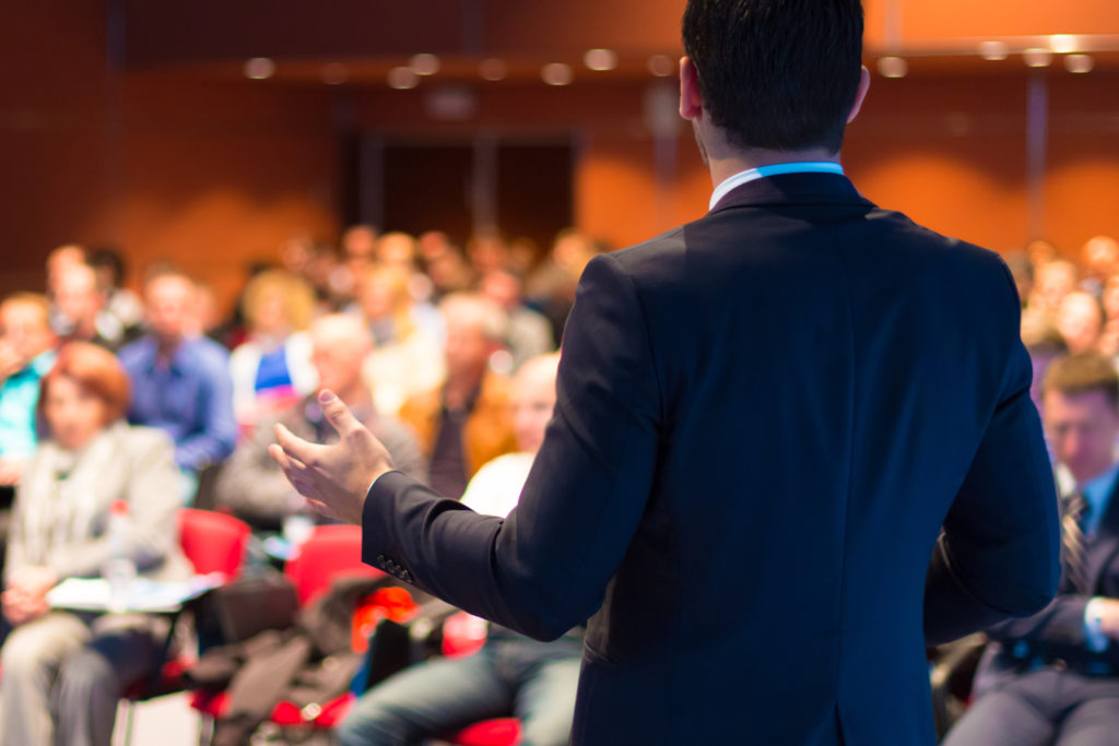 Man-Giving-Speech-at-Conference Man-Giving-Speech-at-Conference