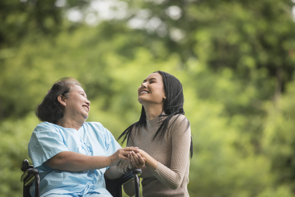 caregiver helping elder in wheelchari