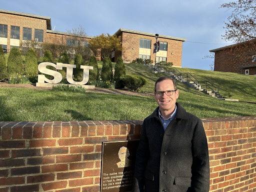 Dr. Aaron Blight standing in front of Shenandoah University, where he serves as a professor.