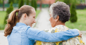 MIddle-aged daughter with her arm around her mother's shoulders