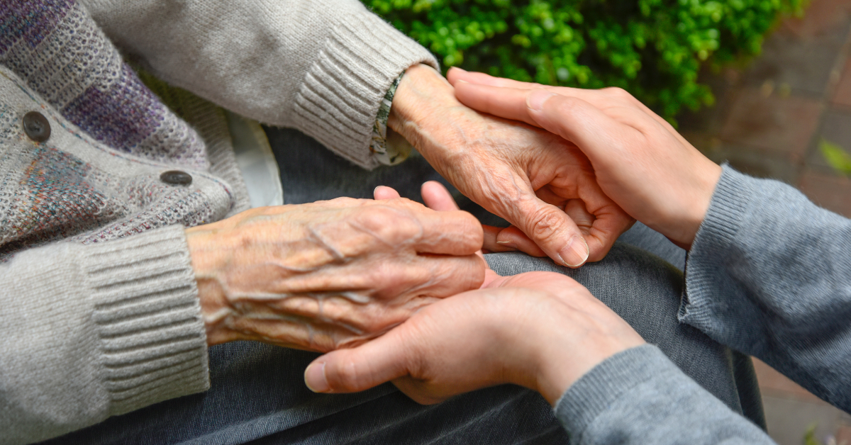 Caregiver holding the hands of someone with dementia