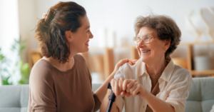An adult woman is sitting with her elderly mother.